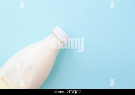 Plastic bottle with milk on blue surface, lay out, top view Stock Photo