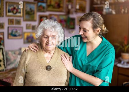 Friendly nurse supporting an elderly lady Stock Photo