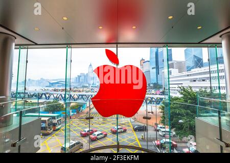 Hong Kong, China - December 4, 2016: close up of Red Apple signboard in Apple store of IFC Mall, Central District skyline outside the crystal glass Stock Photo