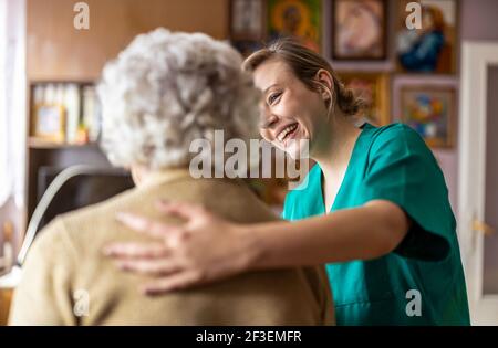 Friendly nurse supporting an elderly lady Stock Photo