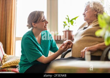 Friendly nurse supporting an elderly lady Stock Photo