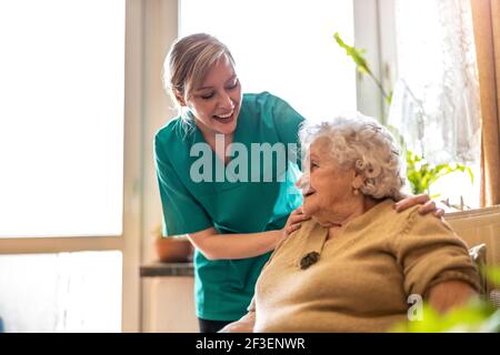 Friendly nurse supporting an elderly lady Stock Photo
