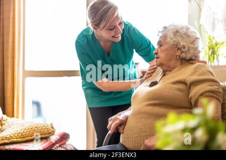 Friendly nurse supporting an elderly lady Stock Photo