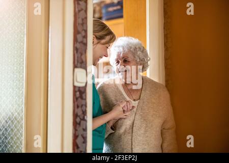 Friendly nurse supporting an elderly lady Stock Photo