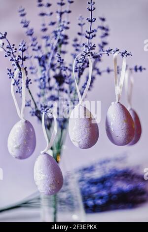 Purple Easter eggs hanging on lavender branches Stock Photo