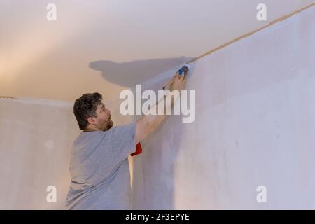 Professional painter using a brush to paint on wall Stock Photo