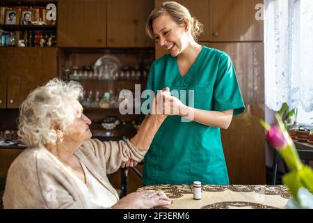 Friendly nurse supporting an elderly lady Stock Photo