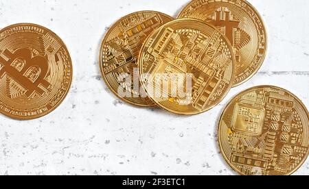 Top down view, golden commemorative btc - bitcoin cryptocurrency - coins scattered on white stone board, closeup detail Stock Photo