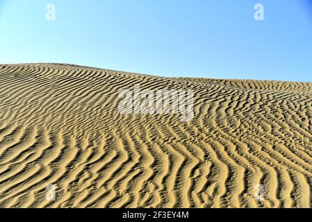A breathtaking view of sand dunes ripples of Al Qudra desert and a clear blue sky, Dubai, United Arab Emirates Stock Photo