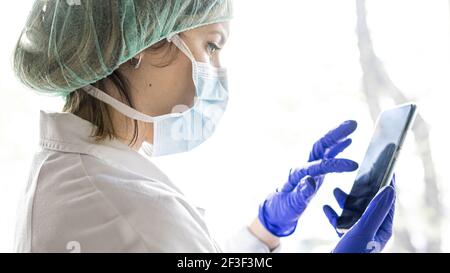 A shallow focus closeup of a female medical practitioner using a smartphone in the hospital Stock Photo