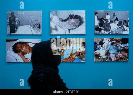 Halabja, Iraq. 16th Mar, 2021. A woman walks past photos of victims of the Halabja chemical attack.The 33rd anniversary of the chemical attack carried out by the Iraqi government on March 16, 1988 on the city of Halabja in the Kurdistan Region, which killed nearly 5000 people and injured 10000 most of them civilians. Thousands of the city's residents died in the year following the attack due to health complications and due to diseases and birth defects. (Photo by Ismael Adnan/SOPA Images/Sipa USA) Credit: Sipa USA/Alamy Live News Stock Photo