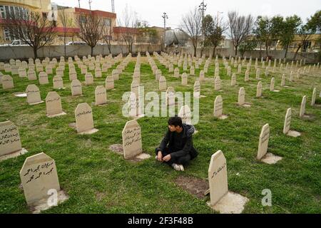 Halabja, Iraq. 16th Mar, 2021. A man sits in the graveyard of the victims of the Halabja chemical attack.The 33rd anniversary of the chemical attack carried out by the Iraqi government on March 16, 1988 on the city of Halabja in the Kurdistan Region, which killed nearly 5000 people and injured 10000 most of them civilians. Thousands of the city's residents died in the year following the attack due to health complications and due to diseases and birth defects. (Photo by Ismael Adnan/SOPA Images/Sipa USA) Credit: Sipa USA/Alamy Live News Stock Photo