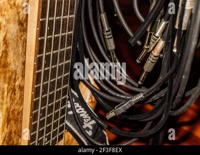Shot of a wooden 5 strings electric bass guitar with jacks and cables Stock Photo