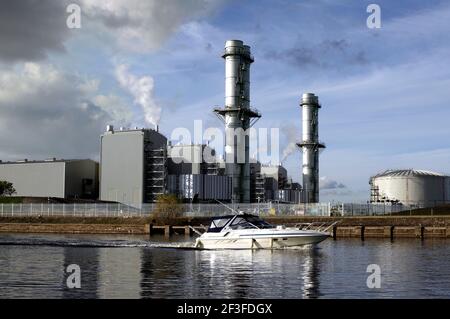 Boat on the River Trent passing Staythorpe C combined cycle gas turbine (CCGT) power station, near Newark-on-Trent, Nottinghamshire. Stock Photo