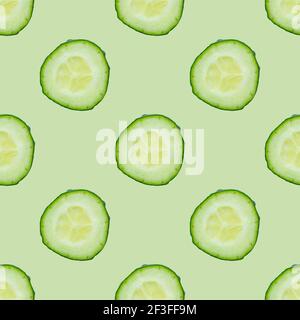 Seamless pattern of fresh cucumber slices isolated on green background. Top view Stock Photo