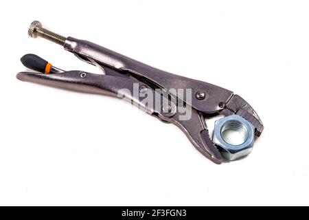 Adjustable wrench with a tightened nut. Accessories for mechanics carrying out repairs in the household. Light background. Stock Photo