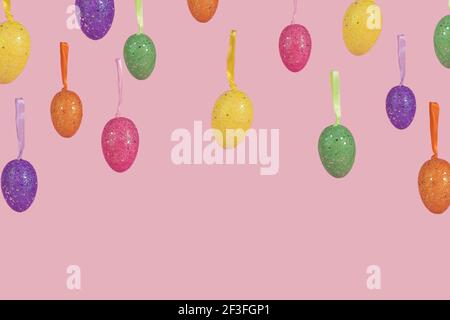 Creative Easter layout made of flying colorful eggs on light pink background. Minimal easter concept. Easter card with copy space for text. Stock Photo
