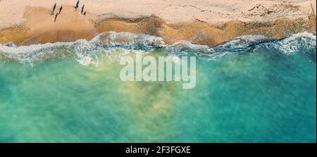 Empty tropical sand beach and azure sea or ocean water aerial top view from drone, panoramic long banner with copy space. Stock Photo