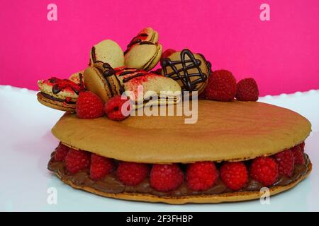 A giant chocolate macaron cake with fresh raspberries Stock Photo