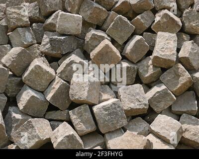 Pile of gray street paving mostly cubic shape before stealing the road surface, as a background, close-up Stock Photo