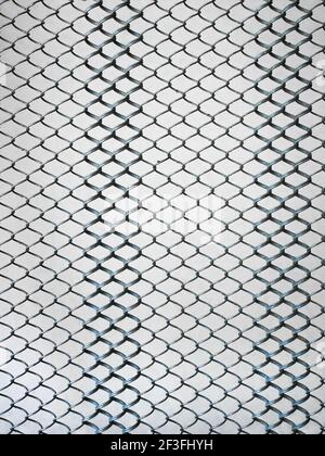 Metal springy mesh with chain link on a beige background, part of an old steel mattress with iron linked elements, close-up, vertical Stock Photo