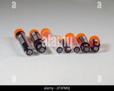 An assortment of jacketed and non-jacketed 2D barcoded biological sample tubes. Stock Photo