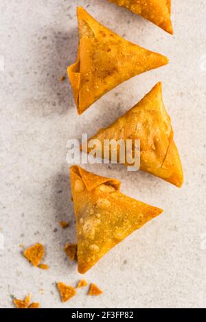 Samosa triangles placed in a pattern on a light surface Stock Photo