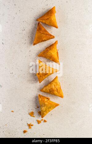 Samosa triangles placed in a pattern on a light surface Stock Photo
