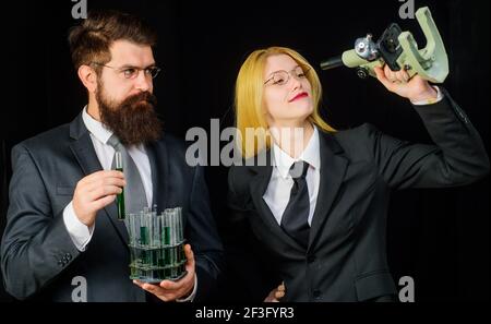 Laboratory assistants with test tubes and microscope. Students in university laboratory. Lab experiment. Chemistry science. Stock Photo