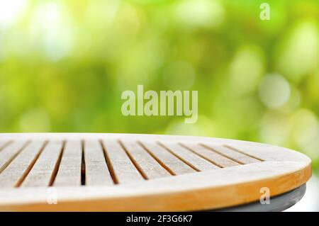Round wood table top on green bokeh abstract background - can be used for display or montage your products Stock Photo