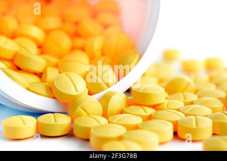 Small medicine tablets (or pills) spilling out from the bottle Stock Photo