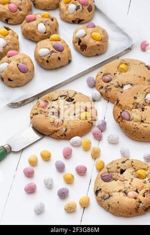 Homemade chocolate mini egg cookies and the raw cookie dough on a baking tray Stock Photo