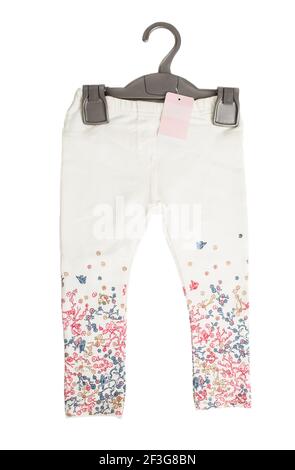 White denim jeans with floral pattern on black plastic hanger. Isolated on a white background. Stock Photo