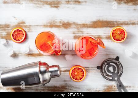 Cocktails with blood oranges, a shaker, and a strainer Stock Photo