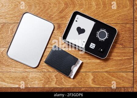 Metallic case with a set of poker cards, dice and chips for leisure activity. Wooden table surface. Leisure activity and entertainment concept Stock Photo
