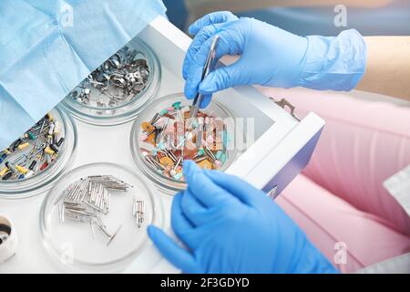Dental surgeon lifting a single prophy cup from tray Stock Photo