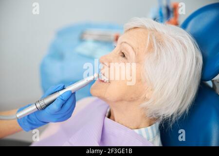 Dental drill with prophy cup cleaning pensioner teeth Stock Photo