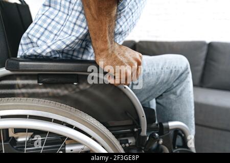 Black disabled man sits down on wheelchair at home Stock Photo