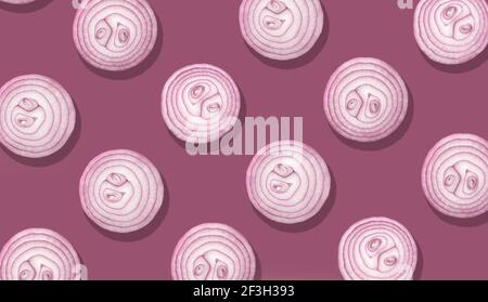 onion slices on purple background, top view Stock Photo