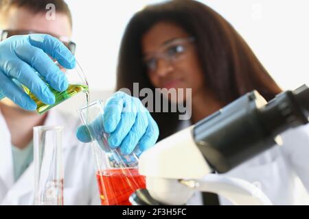 Two researchers are conducting experiments with chemical liquid in laboratory Stock Photo