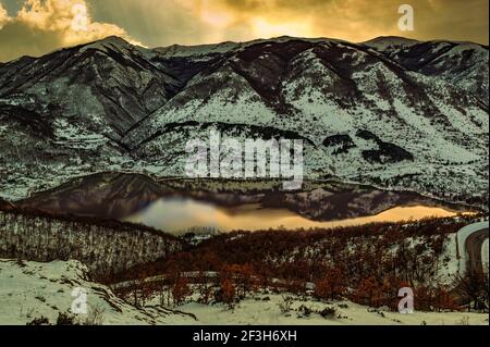 the lake of scanno reflects the golden colors of an Abruzzo sunset. Abruzzo, Italy, Europe Stock Photo