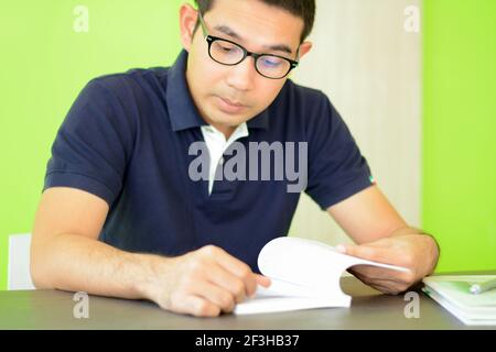 A man reading book on the table - studying & exam concept Stock Photo