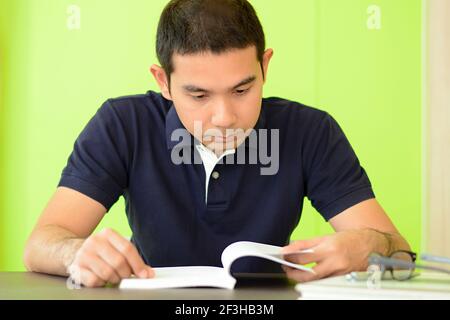 A man reading book on the table - studying & exam concept Stock Photo