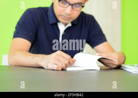 A man reading book on the table - studying & exam concept Stock Photo