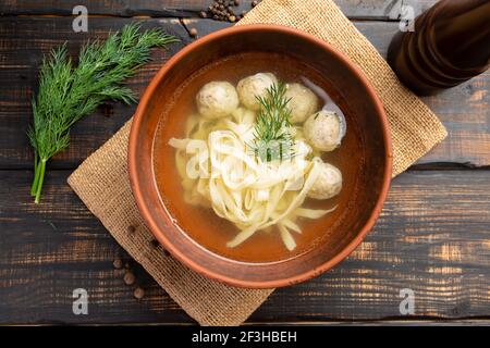 Noodle soup with meatballs with parsley and dill on dark wooden background Stock Photo
