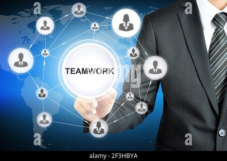 Businessman hand pointing on TEAMWORK sign on virtual screen with human icons linked as network Stock Photo