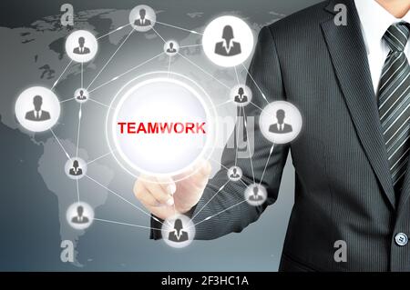 Businessman hand pointing on TEAMWORK sign on virtual screen with human icons linked as network Stock Photo