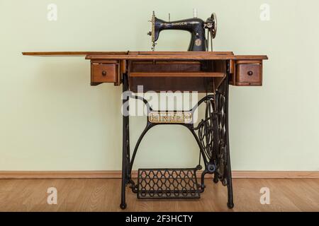 Bacau,Romania - May 16, 2011: Image of the old Singer Sewing machine in a empty room with parquet. Issac Singer built the first sewing machine with ve Stock Photo