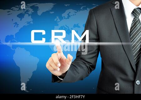 Businessman pointing to CRM (Customer Relationship Management) sign on virtual screen Stock Photo