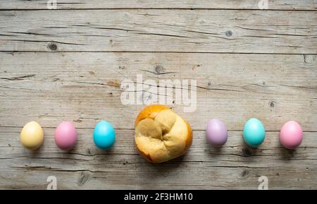 small easter bread pinze with some colorful easter eggs on wooden background Stock Photo